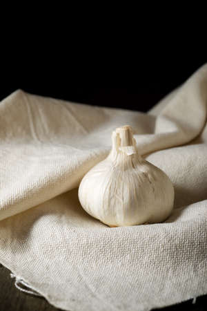 Garlic cloves on a white tablecloth.の写真素材