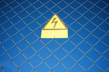 Electrical hazard sign placed on a metal fence.