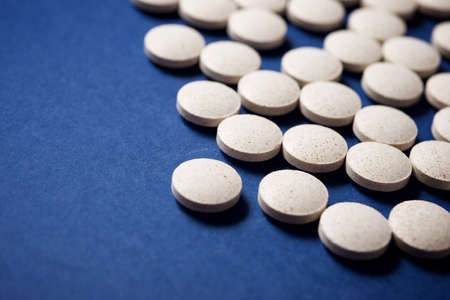 Pills on a blue table.