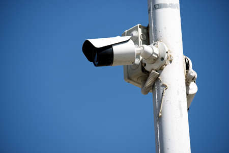 Closeup of a surveillance camera and clear sky.の写真素材