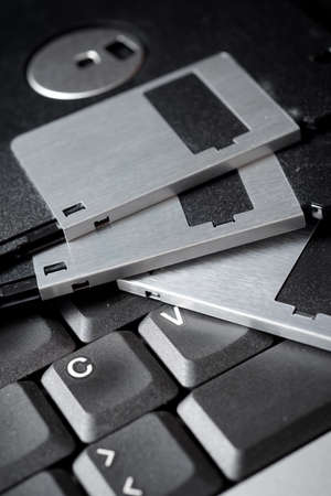 Old floppy disks on a keyboard.の写真素材