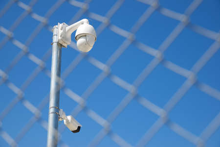 Closeup of a surveillance camera and clear sky.の写真素材