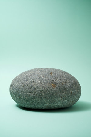 Gray pebble leaning on a green table.の写真素材
