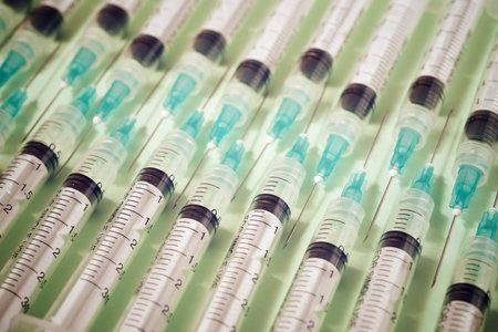 Close up of a group of syringes on a green table.の写真素材
