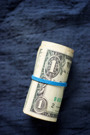 Dollars rolled up with a rubber band on a cloth.の写真素材