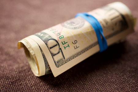 Dollars rolled up with a rubber band on a cloth.の写真素材