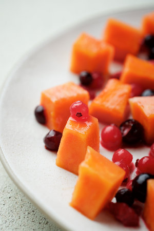 Papaya pieces and berries in a dishの写真素材
