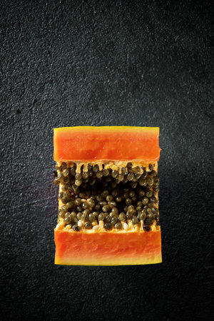 Papaya chunk on a black tableの写真素材
