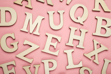 Wooden letters to play on a pink tableの写真素材