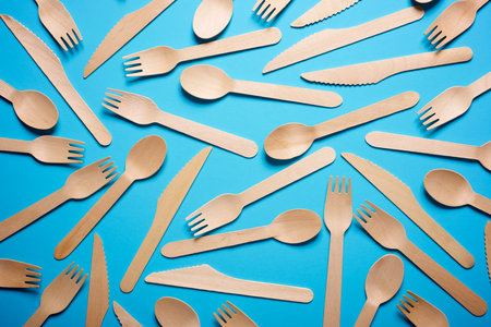 Pieces of disposable wooden cutlery on a blue tableの写真素材