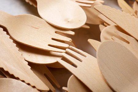 Pieces of disposable wooden cutlery on a tableの写真素材