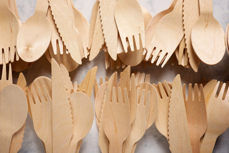Pieces of disposable wooden cutlery on a tableの写真素材