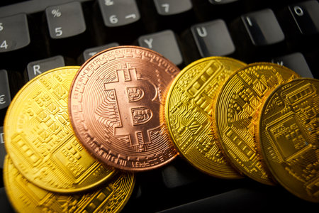 Bitcoin coins stacked on a black computer keyboardの写真素材
