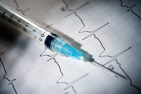 Closeup of a syringe on paper electrocardiogramの写真素材