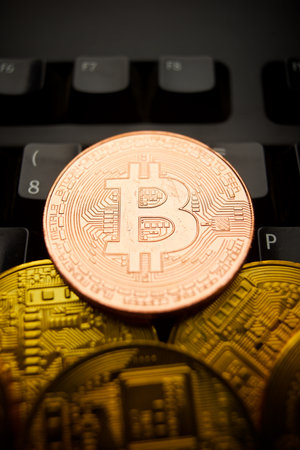 Bitcoin coins stacked on a black computer keyboardの写真素材