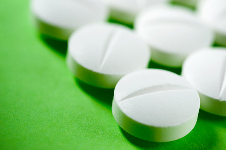 White medicine tablets on a green tableの写真素材