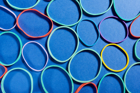 Close up of a group of elastic bands on a blue tableの写真素材