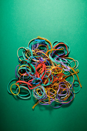 Close up of a group of untidy elastic bands on a green table