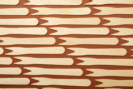 Pieces of disposable wooden forks on a brown tableの写真素材
