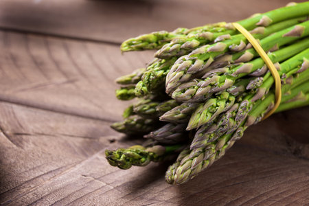 Group of wild asparagus on a wooden tableの写真素材