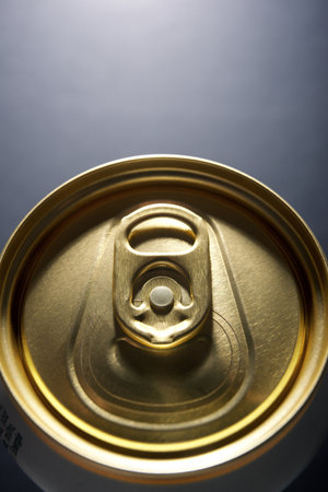 Closeup of a golden beer can on a gray tableの写真素材