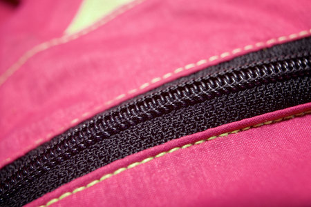 Close-up of the zipper of an old pink and yellow mountain rain jacketの写真素材