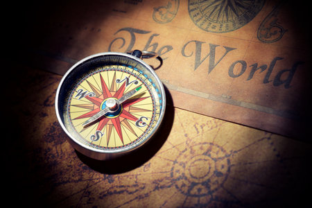 Close-up of a vintage compass on an antique paper mapの写真素材
