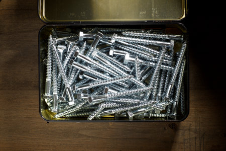 Close-up of many metal metric hexagonal screws in a metallic boxの写真素材