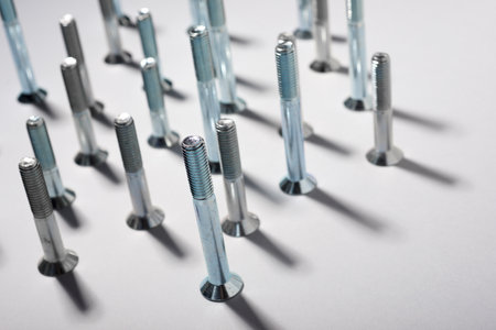 Close-up of many metal metric hexagonal screws on a table.の写真素材