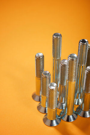 Close-up of many metal metric hexagonal screws on a table.の写真素材