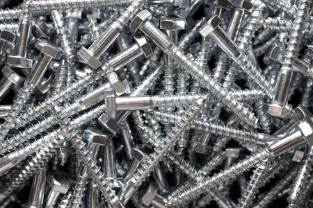 Close-up of many metal metric hexagonal screws on a table.の写真素材