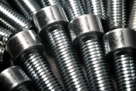 Close up of round-headed metal screws on a tableの写真素材