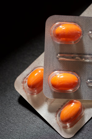 Blister-packed medicine capsules on a black tableの写真素材