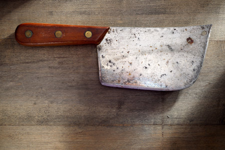 Closeup of a kitchen knife for cutting meat on a wooden table.