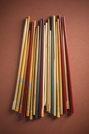 Close up of a group of asian chopsticks on a brown table.の写真素材