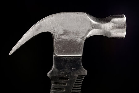 Close up of a metal hammer on a black backgroundの写真素材