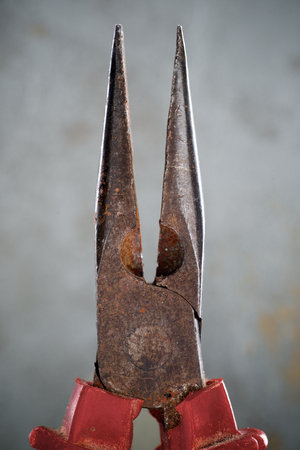 Close up of slim metal pliers on a gray backgroundの写真素材