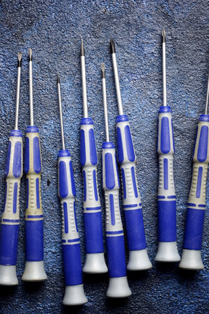 Close up of precision screwdrivers group on a blue surfaceの写真素材