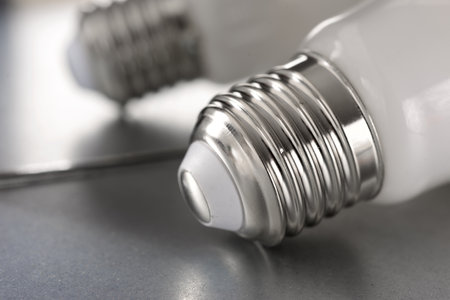 Close up of an energy-saving light bulb socket on a metal surfaceの写真素材