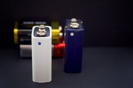 Close up of four small rectangular nine volt batteries on a black tableの写真素材