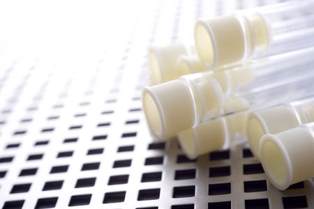 Close up of a group of plastic test tubes on a metal grating surface