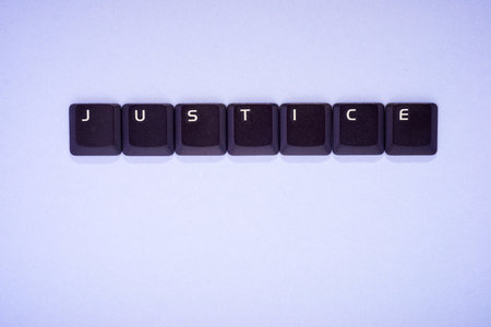 Close up of the keys of an old keyboard laptop creating justice wordの写真素材