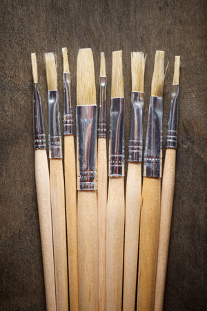 Close up of a group of artistic brushes on a wooden tableの写真素材