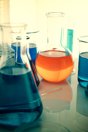 Close up of test-tube glass beaker with liquid standing on a laboratory countertopの写真素材