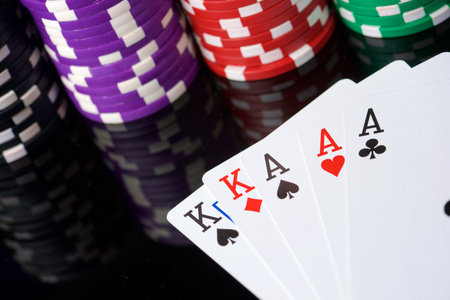 Close-up of a group of casino chips and poker cards on a blue surface