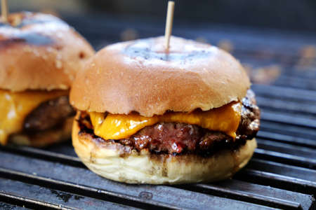 Cheese burger, tomato and bread made in barbecue grill. Side view. Close up.の写真素材