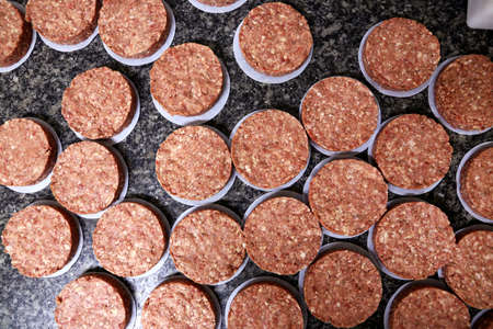 many raw hamburgers outside the restaurant. Starting the preparation of hamburgers. Top view.