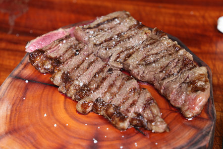 Rump steak or Rump Steak. Cutting a juicy steak on a wooden board.の写真素材