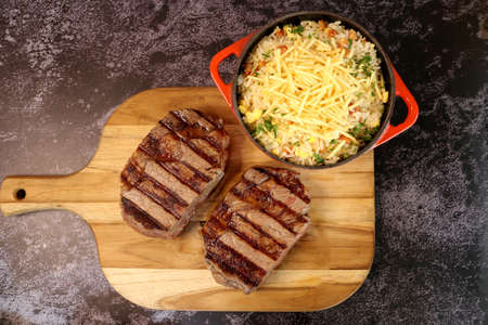 Delicious juicy Ancho steak with grill marks and accompaniment of farofa on the side. Brazilian food. Top view.の写真素材