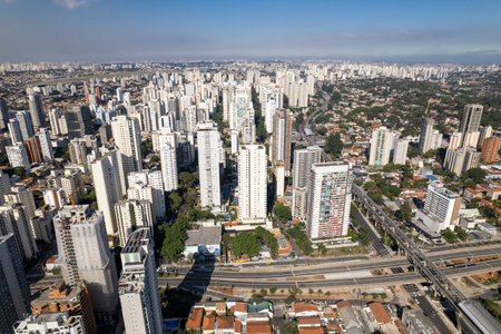 This vibrant aerial panorama captures Campo Belo in SÃ£o Paulo with its mix of modern high-rises and residential areas, set against a clear blue sky.の写真素材